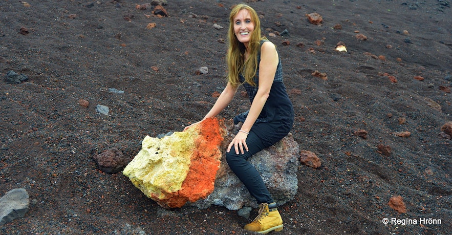 Regína sitting on colourful lava by Eldfell volcano