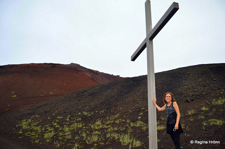 Regína by A memorial cross at the roots of Eldfell volcano