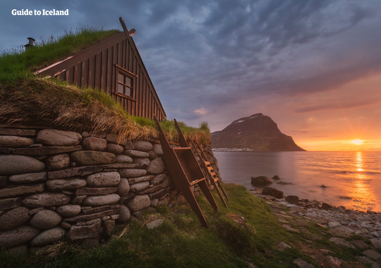 午夜阳光下的冰岛西峡湾草顶房