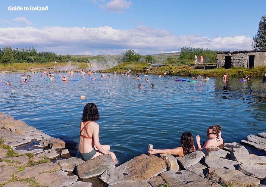 Folk slapper av i vannet i Den Hemmelige Lagune på Island