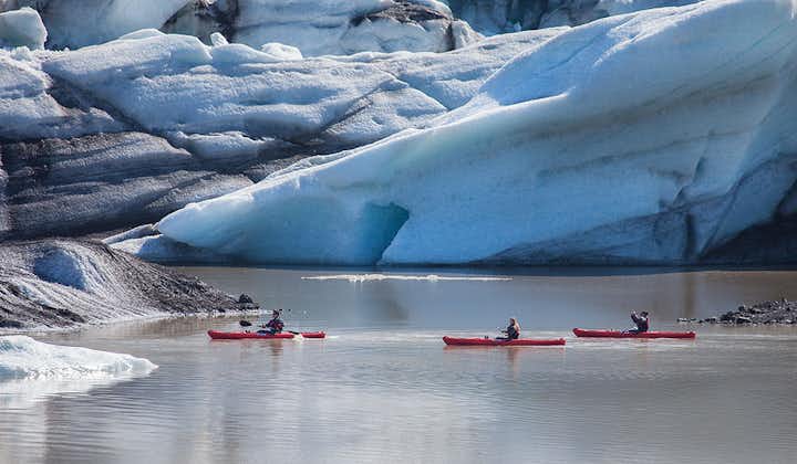 在冰岛索尔黑马冰川冰河湖的巨型浮冰之间玩皮划艇