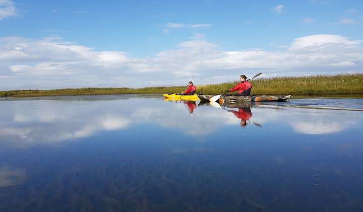 Two adventurers kayaking on a calm summer day in the south Icelandic rivers.