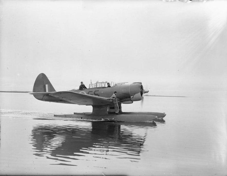 A Northrop N3P-B aircraft, floating in the water at Akureyri, October 1941. An engineer stands on the plane, ready to check its engines.