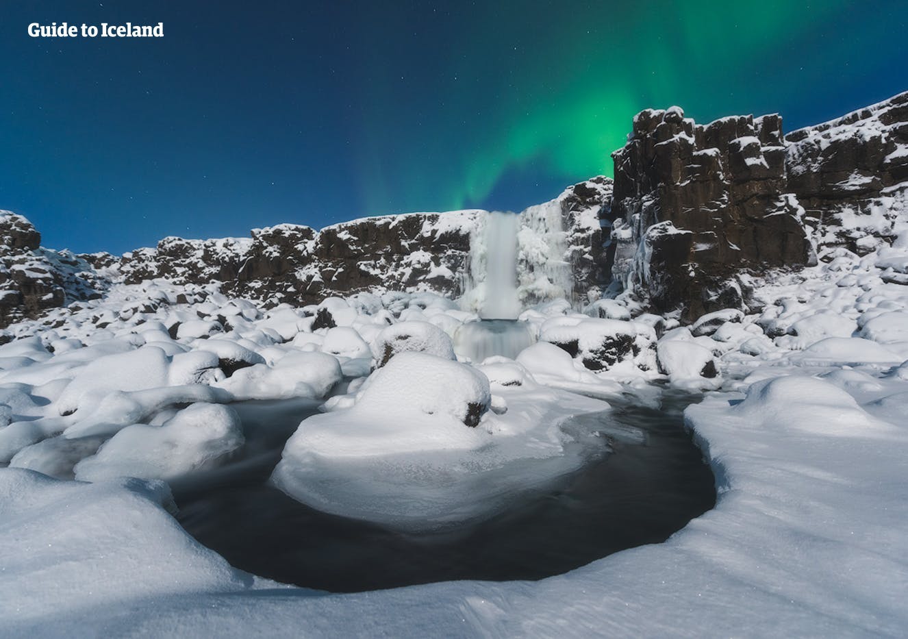 Schneebedeckter Boden und Nordlichter im Þingvellir-Nationalpark.