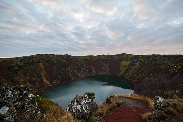 See the red walls and turquoise water of the crater lake Kerið on this Golden Circle minibus tour.