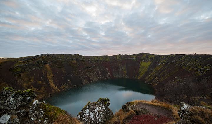 See the red walls and turquoise water of the crater lake Kerið on this Golden Circle minibus tour.