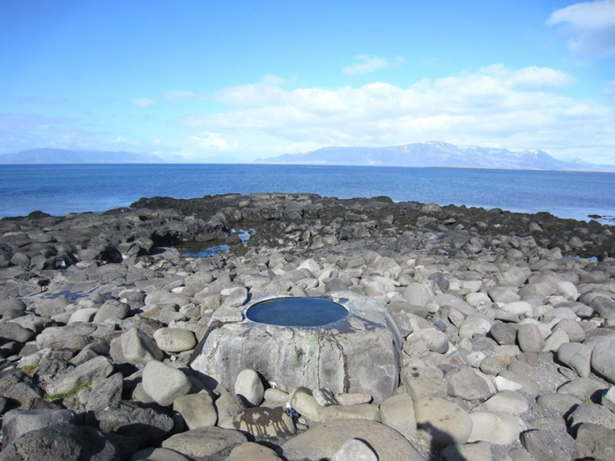 Het Kvika-voetbad bevindt zich aan de kust bij Reykjavík, met uitzicht op de bergen