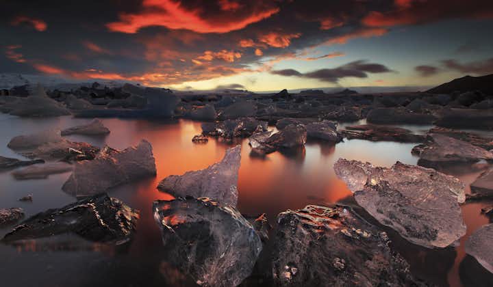 夕暮れの太陽とヨークルスアゥルロゥン氷河湖