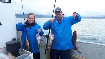 Proud anglers displaying their impressive catches during an exciting day on the sea fishing tour.