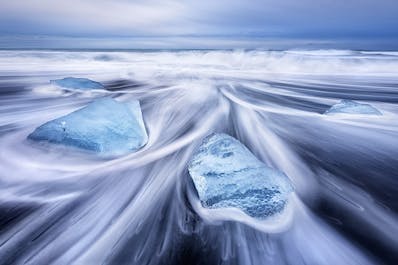 在冰岛南部钻石沙滩的墨黑色沙砾上的浮冰碎片