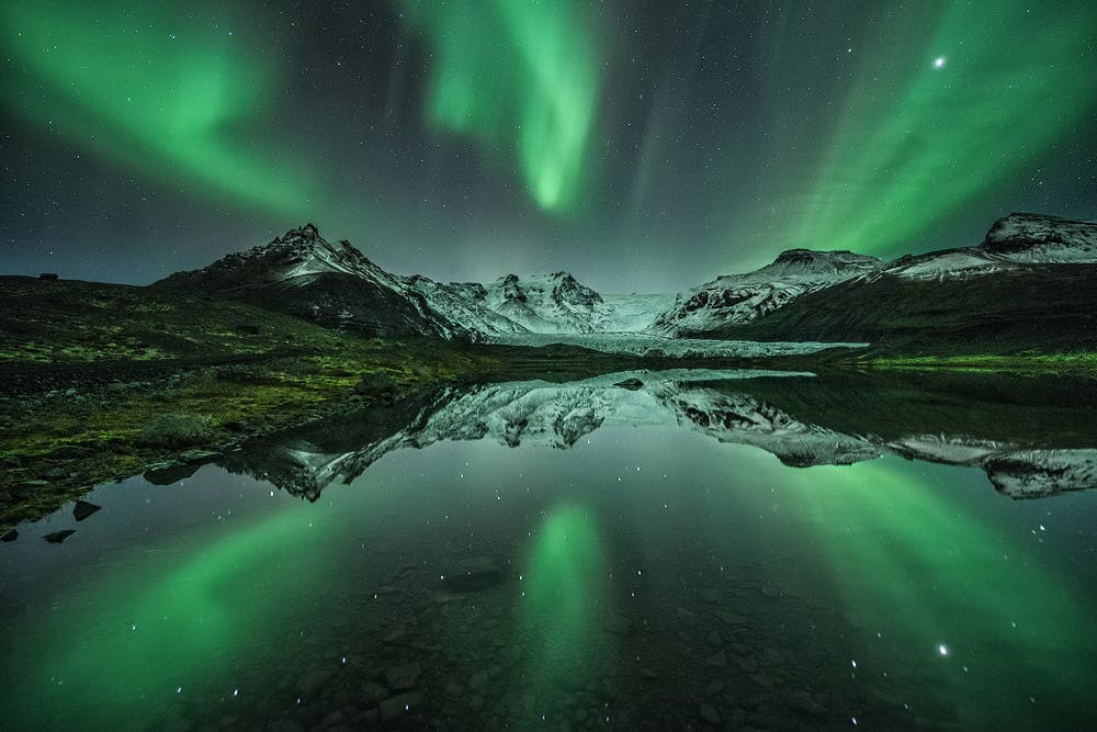 湖の水面に反射されているアイスランドのオーロラ