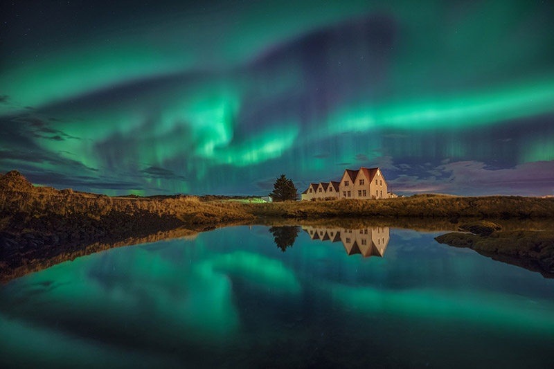 The houses at Þingvellir national park under the northern lights.