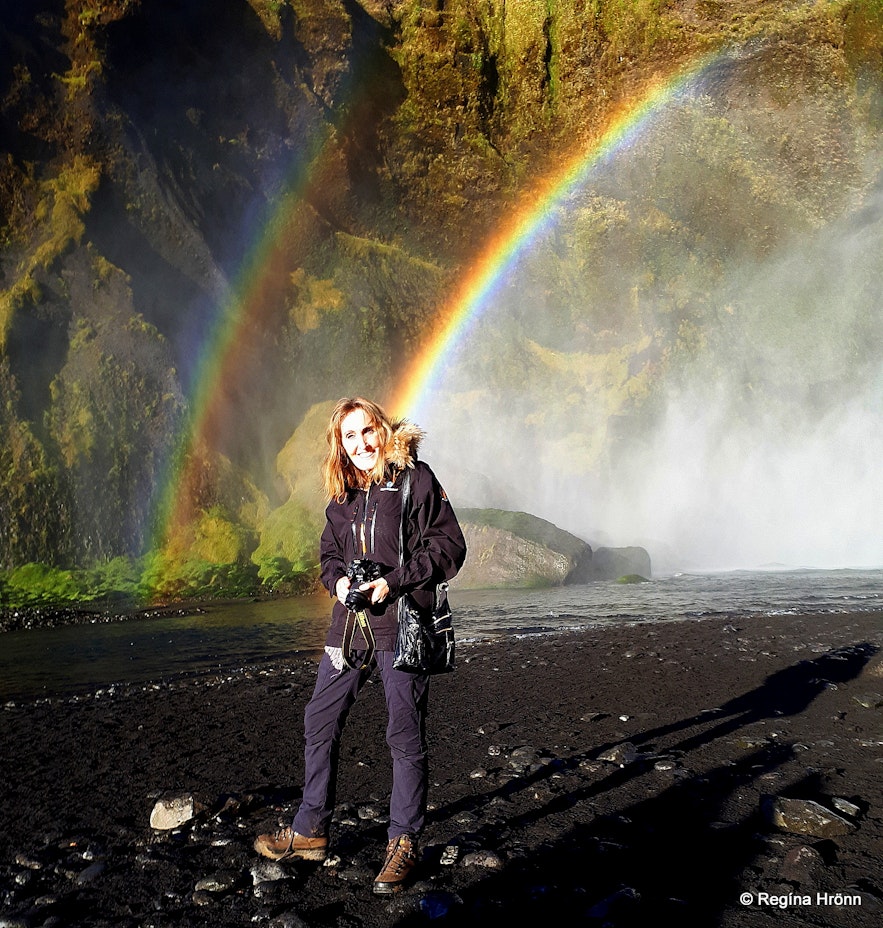 Regína and a rainbow at Skógafoss Waterfall in South-Iceland