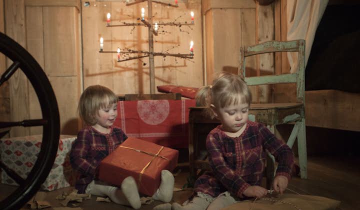 两个冰岛小女孩正在传统的“冰岛圣诞树”下拆礼物