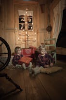 Two little girls open presents by an old styled 'hanger tree', as were common in Iceland in the 19th and early 20th century.