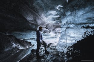 Een reiziger verkent een ijsgrot in Zuid-IJsland