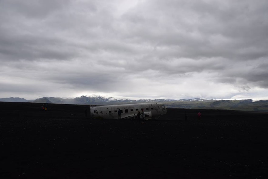 DC-3飛行機の残骸と黒い砂地