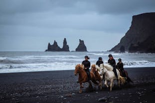 Riders on the sand, with the brisk North Atlantic wind at their back. Reynisfjara black beach, South Iceland.