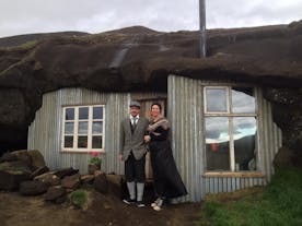 ロイガヴァトンスへトリル（Laugarvatnshellir）の洞窟の家と伝統衣装を着ているアイスランド人