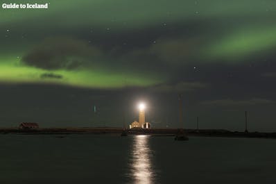 Grótta lighthouse in the greater Reykjavík area, striking an imposing wintery image on a northern lights filled night.