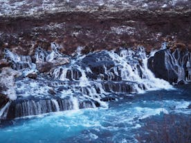 Hraunfossar cascades into blue water