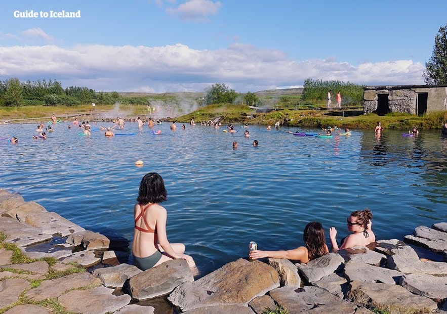 Personnes se baignant dans le Secret Lagoon en Islande