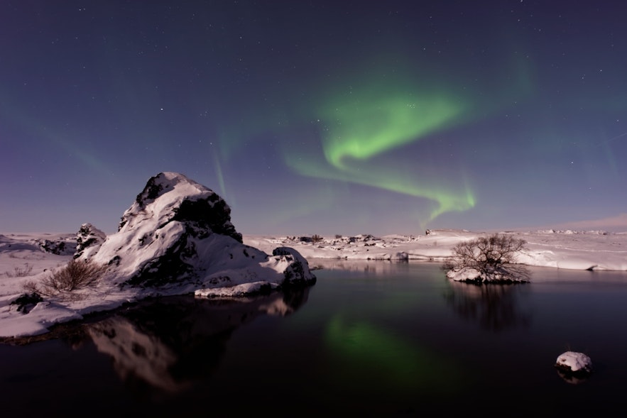 Des aurores boréales brillent sur le lac près d’Akureyri.