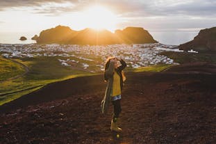 A woman enjoys golden hour in the Westman Islands.