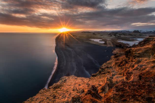 พระอาทิตย์ตกเหนือหาดทรายสีดำไม่มีที่สิ้นสุดของชายฝั่งทางใต้ของประเทศไอซ์แลนด์