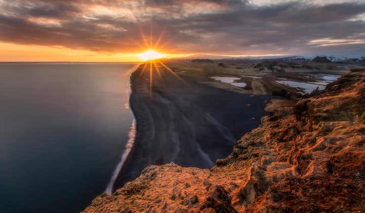 พระอาทิตย์ตกเหนือหาดทรายสีดำไม่มีที่สิ้นสุดของชายฝั่งทางใต้ของประเทศไอซ์แลนด์