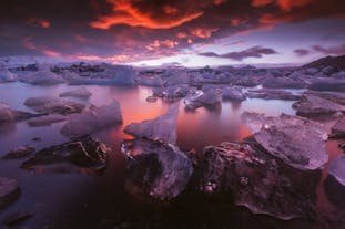 Icebergs scintillants dérivant sereinement sur la lagune du glacier de Jökulsárlón au coucher du soleil.