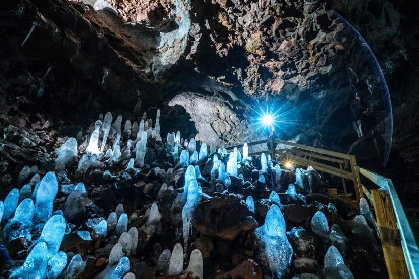 ヴィズゲルミル溶岩洞窟にある石筍、光を挙げて淡く輝いている