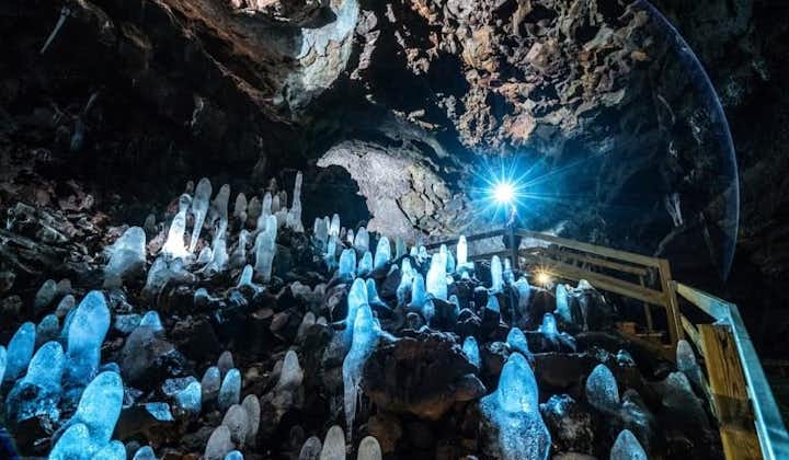 Stalagmiti nella grotta di lava di Vidgelmir che brillano sotto una fioca luce.
