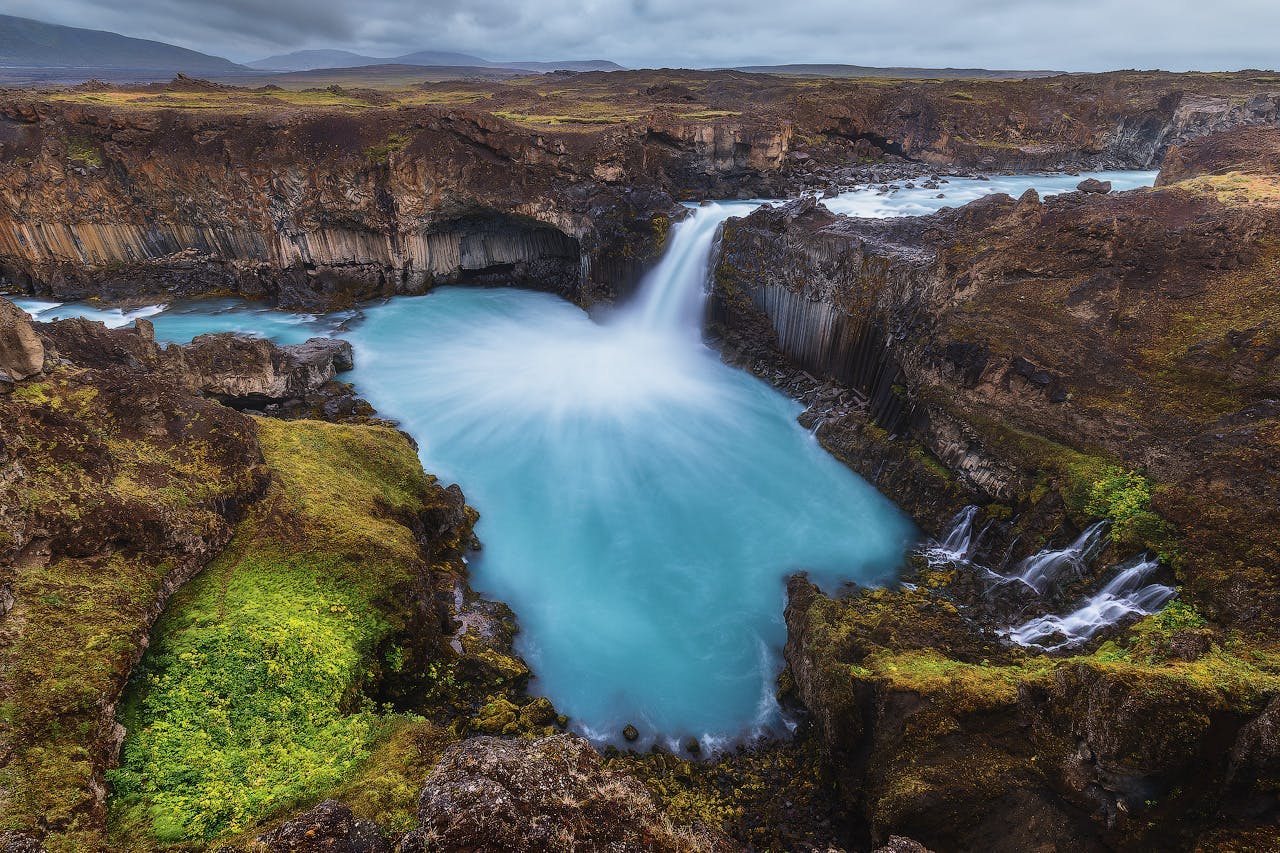 Goðafoss waterfall in summer, with a rainbow arching from it, pictured in north Iceland.