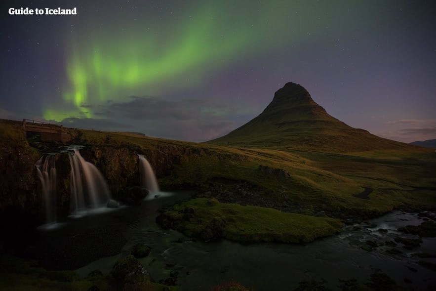 Kirkjufellsfoss and Kirkjufell in west Iceland, beneath the magical Northern Lights.