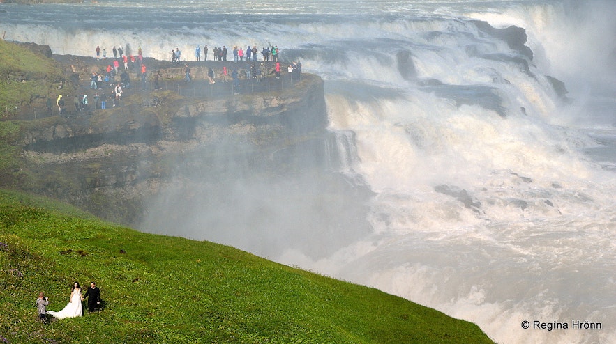 A wedding photoshoot by Gullfoss in heavy mist from the waterfall