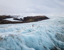A person stands on the Fjallsjokull glacier in Iceland.
