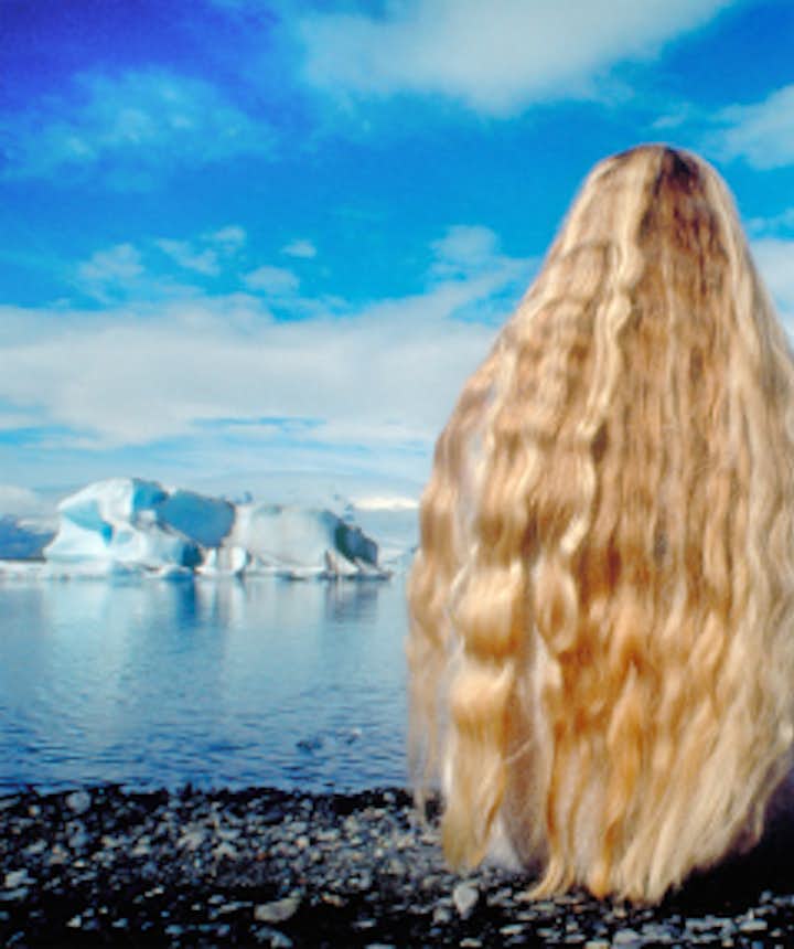 ヨークルスアゥルロゥン氷河湖を眺めるアイスランドの女性