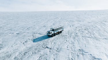 A monster truck crosses the icy slopes of Langjokull glacier.
