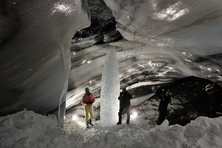 Bezoekers inspecteren een natuurlijk gevormde piek van ijs.