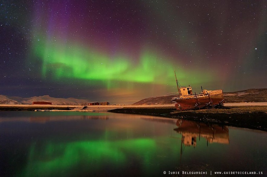 แสงเหนือปรากฏเหนือซากเรือประมงที่ถูกทิ้งในฟยอร์ดทางตะวันตกของไอซ์แลนด์