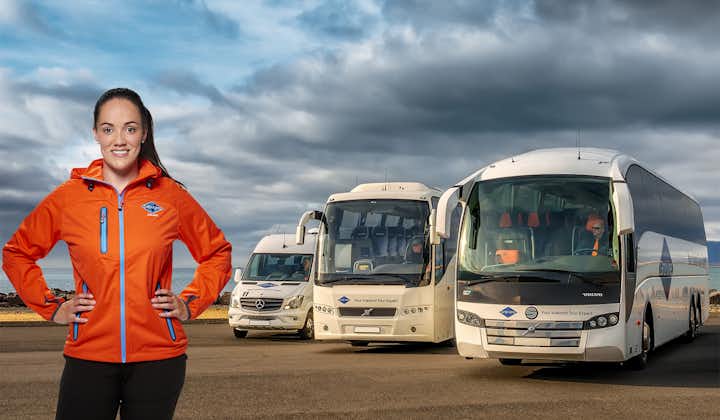 A woman stands in front of one of the company's modern coaches.