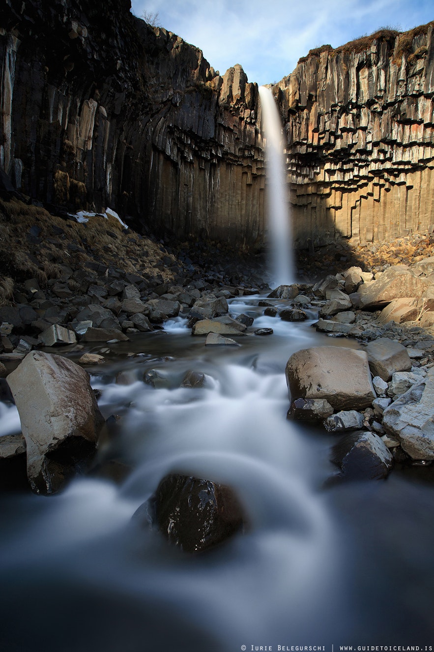 Svartifoss waterfall flowing down against dark basalt columns