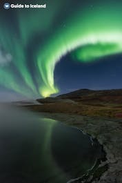 The northern lights shine green, yellow, and white in the Icelandic sky.