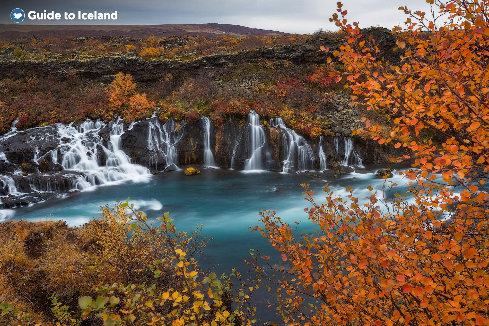 Umgeben von herbstlichen Farben sieht der Wasserfall Hraunfossar noch fantastischer aus als sonst.
