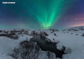 The northern lights shine in the sky above Thingvellir National Park.
