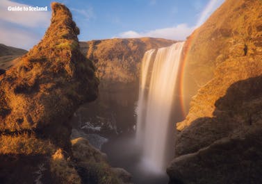 Maak een geweldige foto van jezelf voor de Skógafoss-waterval aan de Zuidkust.