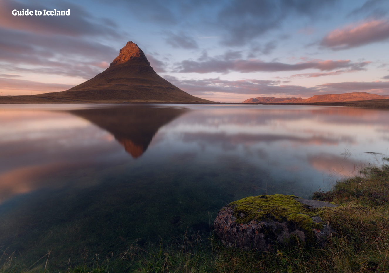 Berget Kirkjufell avspeglat i en sjö under en midsommarkväll på Island.