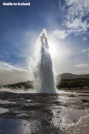 The Strokkur geyser erupts, displaying its mighty power.
