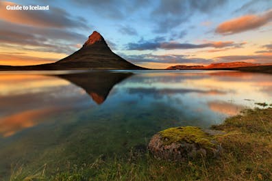 Z wodospadem na pierwszym planie, góra Kirkjufell na półwyspie Snæfellsnes jest jednym z najlepszych miejsc na Islandii, aby stworzyć magiczne zdjęcia.